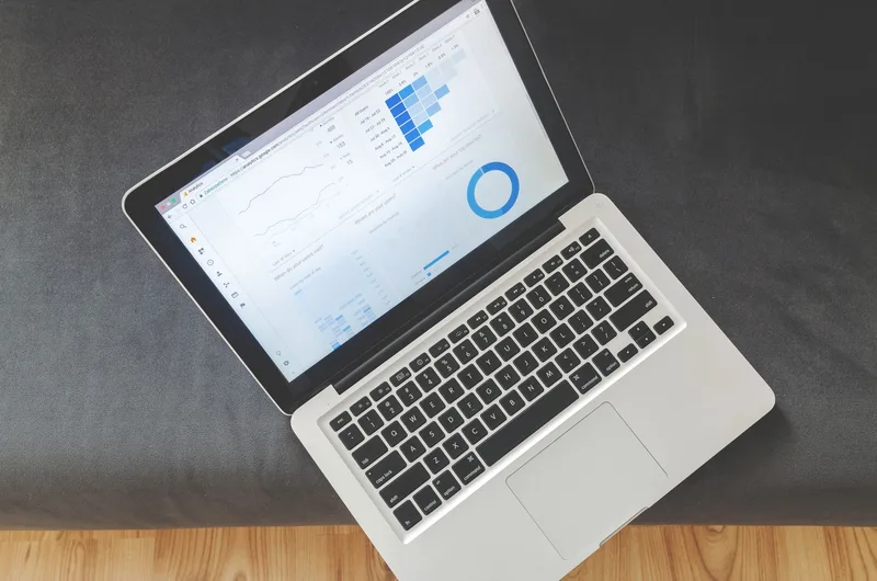 Overhead view of a laptop showing data visualizations and charts representing platform analytics