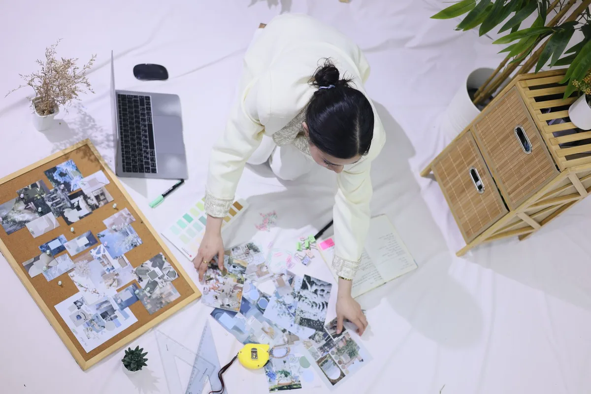 Creator planning a content mood board with color swatches, a corkboard, and a laptop, viewed from above
