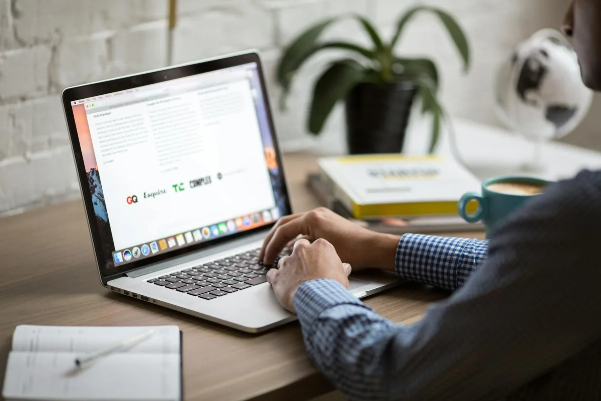 A creator writing a newsletter at their desk, focused on the screen