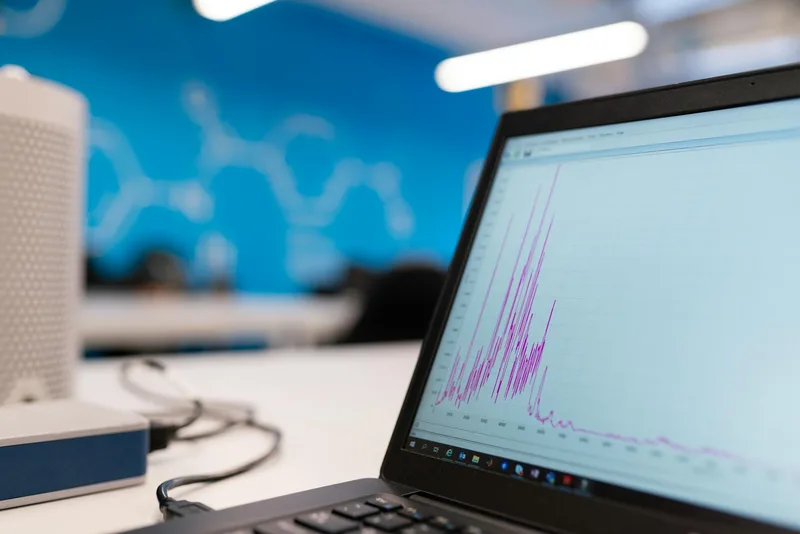 Laptop screen showing email newsletter open rate and click rate analytics with a subscriber growth chart
