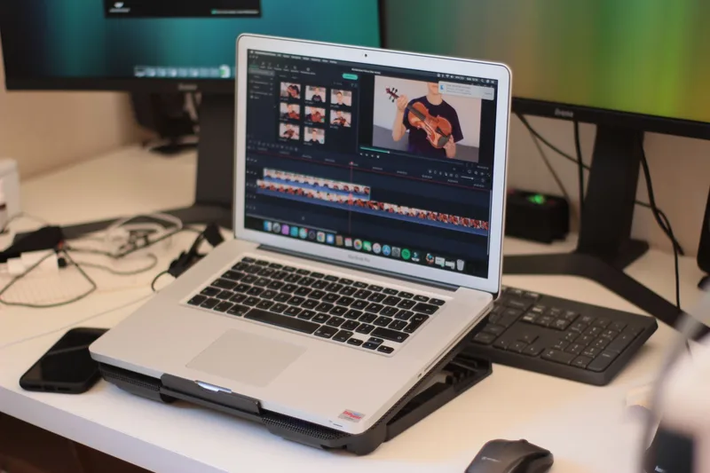 Laptop open to video editing software on a desk, representing uploading Shorts through YouTube Studio on desktop