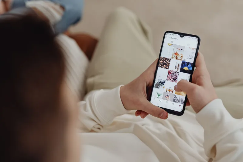 Person browsing their Instagram feed on a smartphone, reviewing posts and evaluating their feed aesthetic